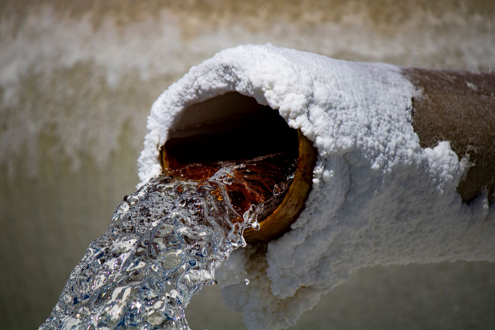 Dépôts d'ocre ferreuse orangés sur un tuyau de drainage