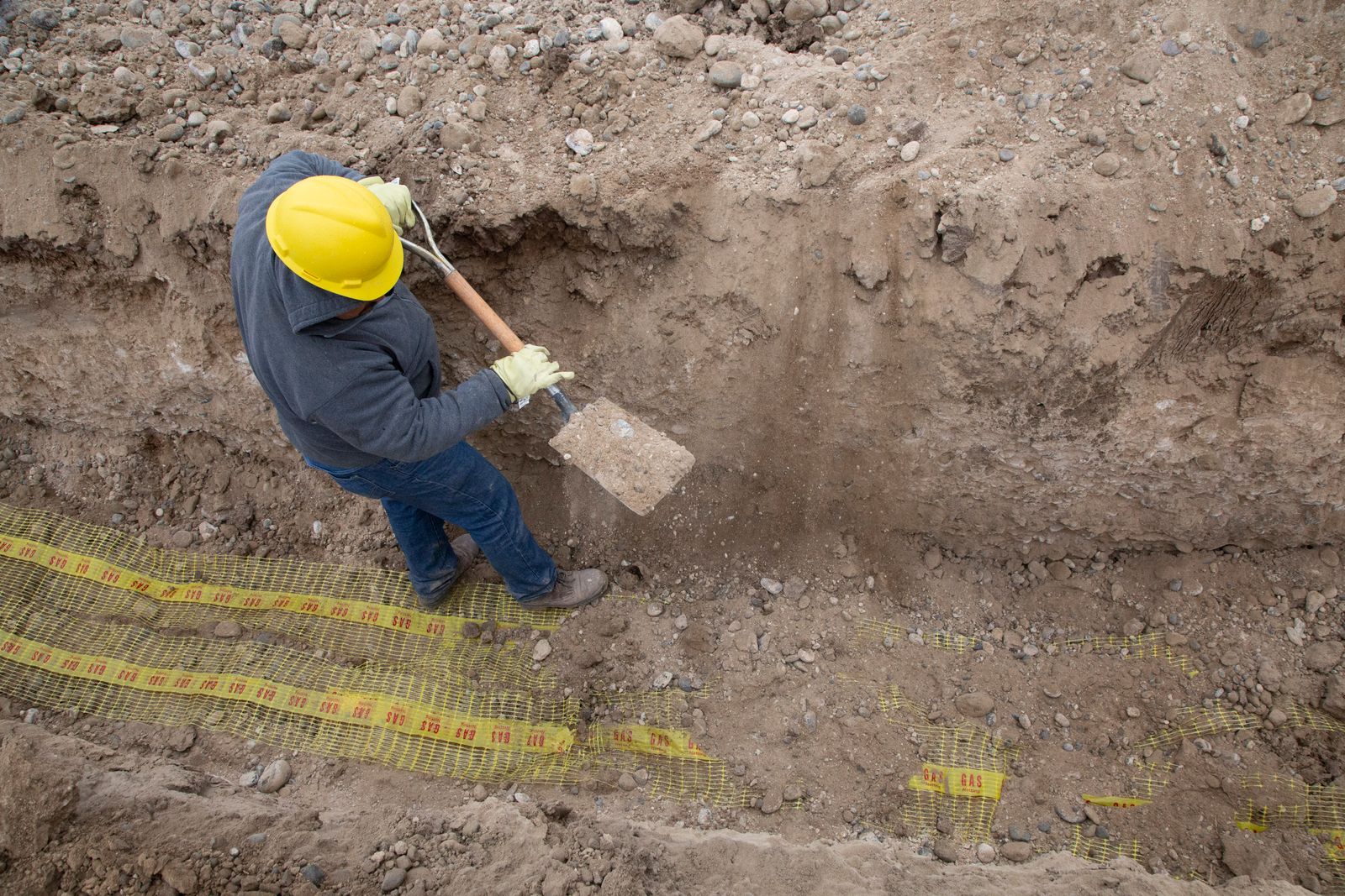 Technicien au travail dans une tranchée d'excavation le long d'une fondation